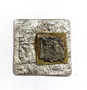 White Metal and brass reticulated and layered pendant.